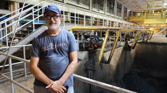Chris Peot, of DC Water, stands by a pit at one of the final stages of the process associated with creating Bloom. He wears a blue t-shirt and blue baseball cap.