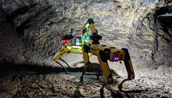 The NASA spot robot navigates an underground lava bed using a flashlight.