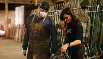 Nieves Longordo, president and owner of Disenos Ornamental Iron in Detroit, is seen on the shop floor with a worker.