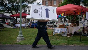 An EMT worker carries a sign advertising free vaccinations against Covid-19 at a farmers market in Northfield, Vermont on June 28, 2021.