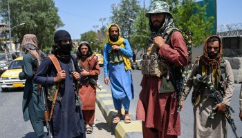 Taliban fighters stand guard along a street near the Zanbaq Square in Kabul on Aug. 16 after a stunningly swift end to Afghanistan's 20-year war, as thousands of people mobbed the city's airport trying to flee the group's feared hardline brand of Islamist rule.