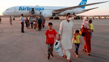 Afghan nationals disembark from a second evacuation airplane carrying Afghan collaborators and their families that landed at the Torrejon de Ardoz air base, 30 km away from Madrid, on August 20, 2021.