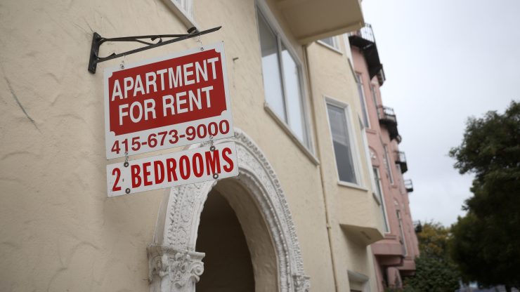 A "for rent" sign posted in front of an apartment building in June in San.
