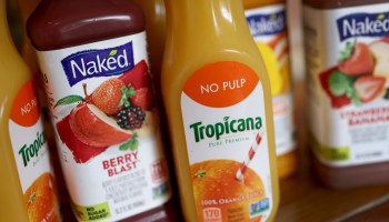 Close-up image of Tropicana and Naked juice bottles.