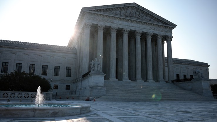 The sun rises behind the U.S. Supreme Court building on Aug. 27 in Washington, D.C.
