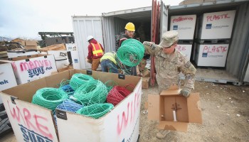Soldiers and civilian contractors sort through supplies near Gardez, Afghanistan, in 2014.