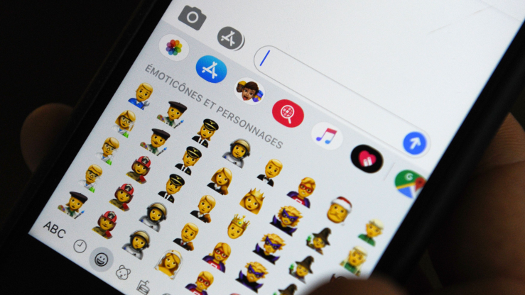 An iPhone shows an array of emoji of different occupations.