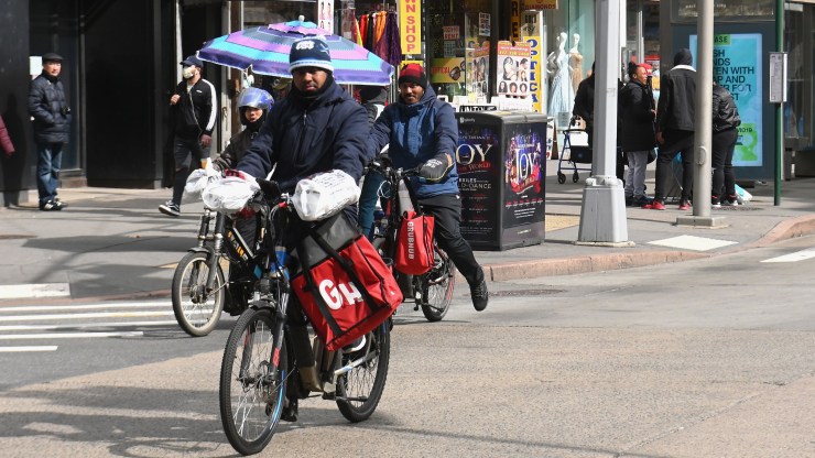 Men on food delivery bikes seen on March 16, 2020 in Brooklyn, New York.