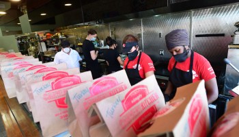 People prepare bagged meals to be donated to medical workers.