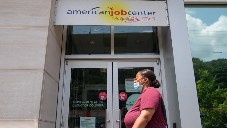 A woman walks past the the DC Department of Employment Services American Job Center, which assists in finding employment for out of work DC residents, in Washington, DC, July 16, 2020.