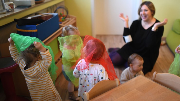 A nursery school teacher plays with children in a day care center.