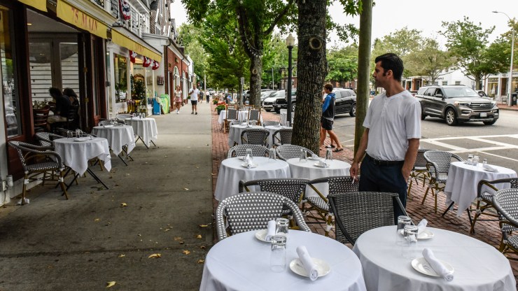 A restaurant employee looks at empty tables on August 21, 2021 in Southampton, New York.