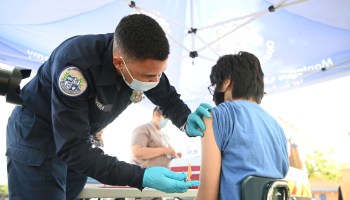 A medical technician administers a COVID-19 vaccine