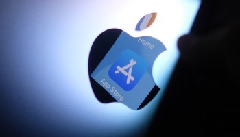 The Apple App store logo is seen reflected in the back of a Mac apple logo.