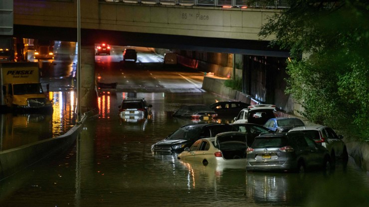 Over six cars are surrounded by water at night on an underpass on Sept. 2 in Brooklyn, New York.