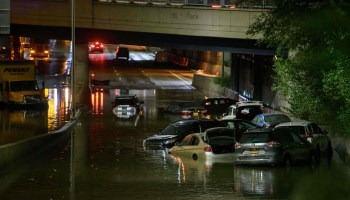 Over six cars are surrounded by water at night on an underpass on Sept. 2 in Brooklyn, New York.