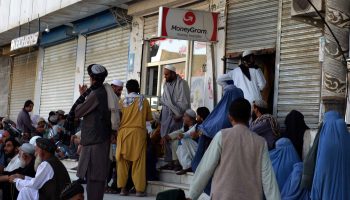 People wait outside a bank in Kandahar, Afghanistan. Banks were temporarily closed after the Taliban seized power, adding to the chaos.