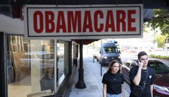 Pedestrians walk past the Leading Insurance Agency, which offers plans under the Affordable Care Act (also known as Obamacare) on January 28, 2021 in Miami, Florida.