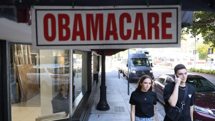 Pedestrians walk past the Leading Insurance Agency, which offers plans under the Affordable Care Act (also known as Obamacare) on January 28, 2021 in Miami, Florida.