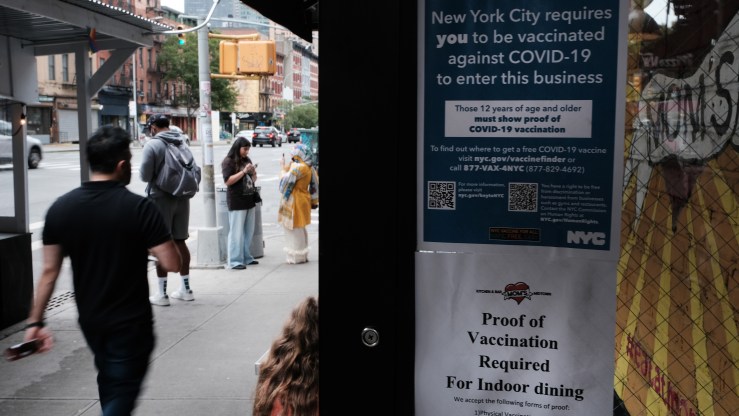 A sign in a restaurant window informs customers that they will need to show proof that they are at least partly vaccinated for Covid-19 to be allowed in the business on August 20, 2021 in New York City.