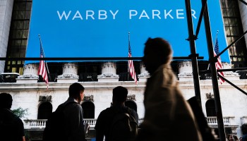 People walk by the New York Stock Exchange as Warby Parker makes its debut on the stock market on Sept. 29.