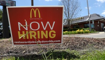 A Now Hiring sign is posted in front of a McDonald's restaurant.