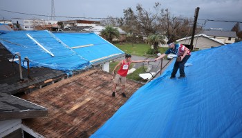 Louisiana residents install a tarp over a damaged roof in the wake of Hurricane Ida. Roofs are a key component in safety but are vulnerable to extreme weather.