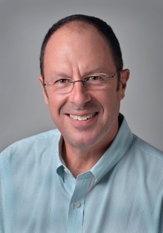 Dr. Paul Robinson smiles for his headshot wearing glasses and a light green collared shirt.