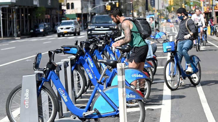 A bicyclist wipes down a Citi Bike before riding during the coronavirus pandemic on April 25, 2020 in New York City.