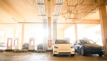 Tesla electric vehicles charge in a parking garage.