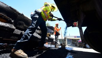 A roadworks crew work on road resurfacing on June 24, 2021 in Alhambra, California.