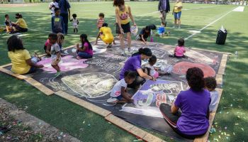 Children and teachers from the KU Kids Deanwood Childcare Center complete a mural in celebration of the launch of the Child Tax Credit on July 14, 2021 at the KU Kids Deanwood Childcare Center in Washington, DC.
