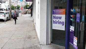 A now hiring sign is posted in the window of FedEx Office store on September 16, 2021 in San Francisco,