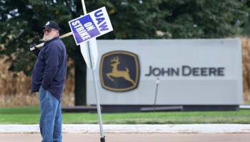 A striking worker pickets a John Deere facility in Davenport, Iowa.