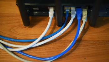 Ethernet cables are seen running from the back of a wireless router in Washington, D.C., on March 21, 2019.