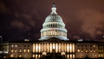 The U.S. Capitol Building is illuminated by white lights at night.