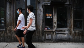 People walk by a closed restaurant in New York City.