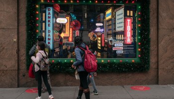 With Christmas only one day away, shoppers walk in front of holiday windows in Midtown, Manhattan on December 24, 2020 in New York City.