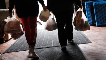 People walk with bags of food after visiting a food pantry in Philadelphia.