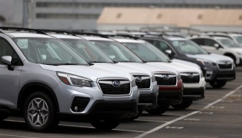 Brand new Subaru cars sit in storage lot.
