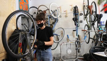 Robin Graven-Milne, owner of Bike Plant, repairs a bike tire at the Bike Plant bike shop in the Bedford–Stuyvesant neighborhood of Brooklyn borough in June in New York City.