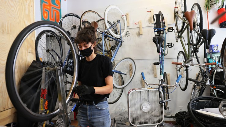 Robin Graven-Milne, owner of Bike Plant, repairs a bike tire at the Bike Plant bike shop in the Bedford–Stuyvesant neighborhood of Brooklyn borough in June in New York City.