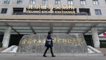 A person walks past the Beijing Stock Exchange. China has expanded its share of global trade this year.