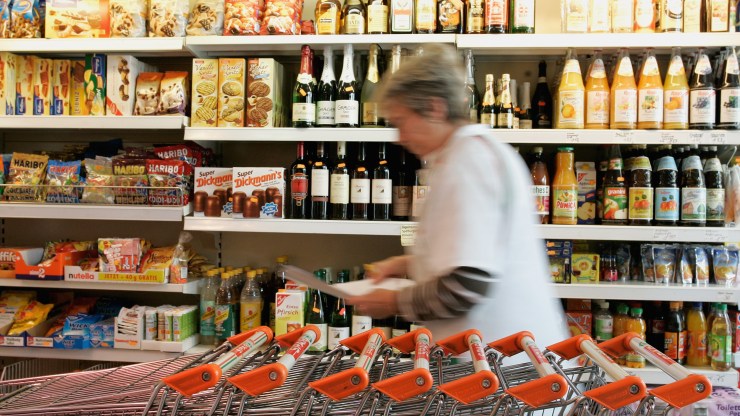 An employee walks past a shelf at a grocery store.