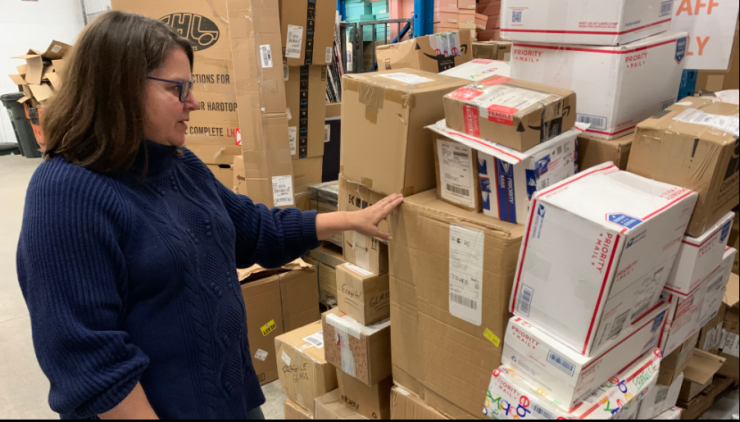 Betsy Smith points to boxes sitting in the warehouse of NAC Logistics.