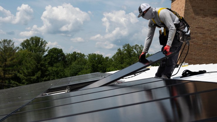 An employee with Ipsun Solar installs solar panels on the roof of the Peace Lutheran Church in Alexandria, Virginia, on May 17.