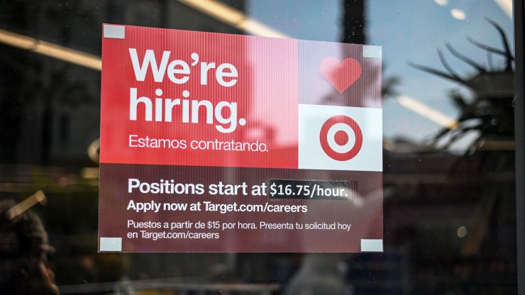 A "We're hiring" sign at a Target store advertises a starting salary of $16.75 per hour.