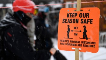 Signage requiring face coverings is displayed as people wear face masks in order to board a ski lift at Lake Louise Ski Resort in Alberta, Canada on November 28, 2021.
