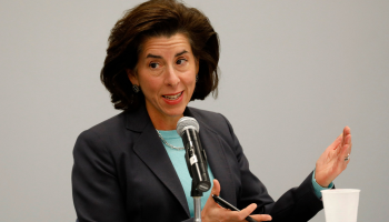 US Commerce Secretary Gina Raimondo speaks into a microphone with her arms gestured in the air.
