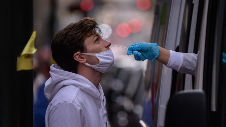 A man receives a nasal swab COVID-19 test at an outdoor test site in New York.